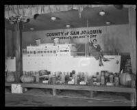 Woman sits upon the San Joaquin County display at the National Orange Show, San Bernardino, 1933