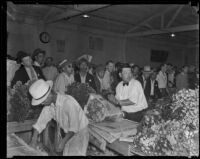 Vendors wrap up flowers for customers at the flower market, Los Angeles, 1935