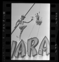 Pianist Liberace, hoisted by crane above Sahara Hotel billboard on the Sunset Strip in Los Angeles, Calif., 1966