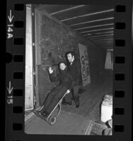 Conductor Zubin Mehta and bassist Dennis Trembly clowning around on loading dock in Los Angeles, Calif., 1975