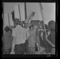 Protester Janet King at the Hall of Justice in downtown Los Angeles talks to pickets after being arraigned on felony charges stemming from the demonstration at Century Plaza during President Johnson's visit. B. 1967