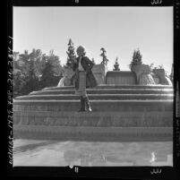 Woman modeling skirt and patent leather rain coat with boots, Los Angeles, Calif., 1962