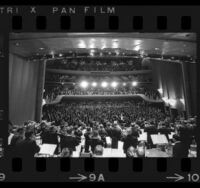 View of Los Angeles Philharmonic on stage from behind, looking out at audience, 1964