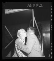 Tom Neal and Barbara Payton kiss at the airport before Payton's trip to London, 1952