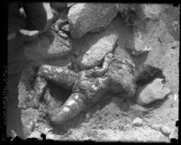 Body of Nina Lee Deloney; caked in dirt, laying in swallow grave amongst rocks; James P. Watson's murder victim, Calif., 1920