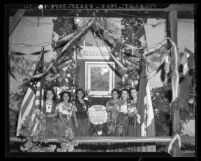 Mexican American women with portrait of Miguel Hidalgo y Costilla on Mexican Independence Day in Los Angeles, 1940