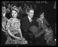 John St. Denis [aka Rev. John Amen-Zat], flanked by two unidentified people in courtroom, Los Angeles, Calif., 1946