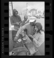 Homeless preparing breakfast at S. Towne Ave. encampment in Los Angeles, Calif., 1987