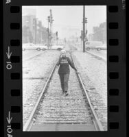 Woman wearing shirt with "Peace Pilgrim" printed on it, walking along railroad tracks in Los Angeles, Calif., 1969