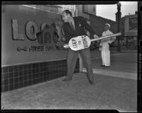 Robert Noble smashes the glass sign of Dalton Auto Loan, Inc. in protest, Los Angeles, 1938