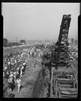 Spectators look on as mechanical crane is readied to remove train wreckage, Glendale, 1935