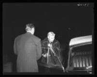 Franchot Tone holds car door for Barbara Payton at Romanoff's, a night spot, 1951