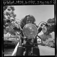 Close-up of Mille Evans riding a motorcycle in Los Angeles, Calif., 1967