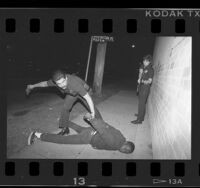 77th Street Division police officers arresting and searching suspect in Los Angeles, Calif., 1989