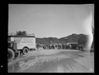 Group of people walking across a street after a catastrophic mudslide, perhaps during relief efforts, Montrose and La Crescenta, 1934