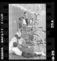 Youngsters and adults watching through chain-link fence at Los Angeles Rams training camp in Fullerton, Calif., 1973