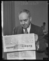 Fred W. Hatch holding newspaper, 1935