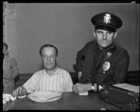 Robbery suspect Alex Smit being held at police station with officer K. E. Kurtz, Los Angeles, 1935