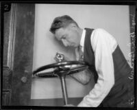 Los Angeles police sergeant Howard L. Barlow inspecting car steering wheel, 1927