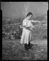 Woman standing on a hill and holding twine having to do with the Mary Skeele kidnapping case, 1933