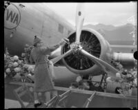 Barbara Douglas christens the TWA City of Los Angeles airplane before its maiden flight, Glendale, [1933]