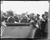 Military men gathered around a convertible car with 5 civilian men, Los Angeles, 1935