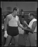 Jerry the Greek laces up the boxing gloves of Kingfish Levinsky, Los Angeles, 1934