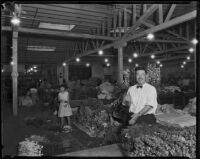 Vendor at the flower market waves to camera, Los Angeles, 1935