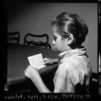 Jack Morales looking at a 1836 California school book written in Spanish, 1970