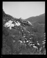 Rescue workers and survivors stand looking at the wreckage of Standard Airlines C-46, 1949