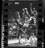 UCLA basketball player, Reggie Miller driving to the net as Washington State players try to block during game in 1985