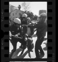 Police restraining a marcher during Chicago Seven protest march in Westwood, Calif., 1970