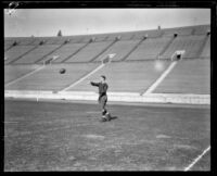 Football player Red Grange throwing football, Los Angeles Coliseum, Los Angeles, 1926