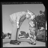 Los Angeles police recruit Robert Peterson receiving sombrero from four-year old Cynthia Ann Martinez of Wilmington, Calif., 1971