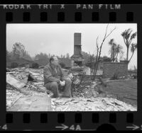 Robert Bray sitting amid remains of home that was destroyed by wildfire in Glendale, Calif., 1975