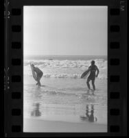 Two surfers walking ashore in Santa Monica, Calif., 1965