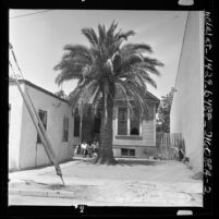 African American women and children sitting on steps of house at 29th and Naomi streets in Los Angeles, Calif., 1962