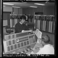 Gemini flight engineer Annette Chambers conferring with co-worker in data processing center om El Segundo, Calif., 1965