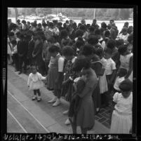 Children and adults with heads bowed in vigil for the four killed in Birmingham, Ala. bombing, Pasadena, Calif., 1963