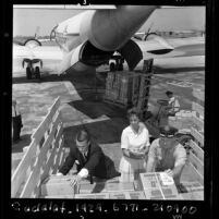 Richard L. Denison, Judy Way and Mark Hessel loading plane for Books for Africa, Calif., 1967