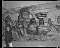 At a mural exhibition at the Los Angeles Central Library, artist Leo Katz points to an area of a cartoon drawing for the Frank Wiggins Trade School mural, Los Angeles, 1934