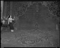 Gwen Steele with an especially large carpet at the National Housing Exposition, Los Angeles, 1935