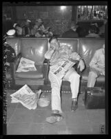 Sgt. B.A. Kainer napping at Union Station with August 12, 1945 with newspaper in his lap, headline reads "WORLD WAITS"