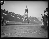 Charley Paddock leaping through finish line at Los Angeles Coliseum, 1920s