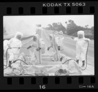 Hazardous materials squad being decontaminated after molten sulfur spill on the 405 Freeway, Calif., 1986