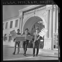 Three Italian actors, one with sign reading "Italians for Italian Roles" picketing at Paramount Pictures gate in Los Angeles, Calif., 1971