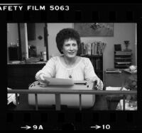 Nancy Ledins, transsexual and former Catholic priest, seated at her typewriter, Van Nuys, 1980