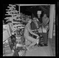 Veteran Allan Jarabin, with Shirley Jones, Dana Wynter and Lydia Lane, receives a present at Lydia Lane's annual Christmas party honoring military veterans, [Los Angeles?], 1963