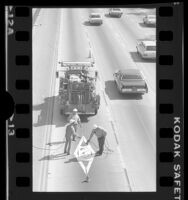 Workers painting diamond on HOV lane, Santa Monica Freeway, Los Angeles, 1976