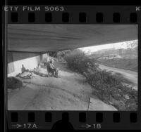 Homeless Joseph Dooley, age 62, sitting on a milk crate under a Hollywood Freeway overpass in Los Angeles, Calif., 1985